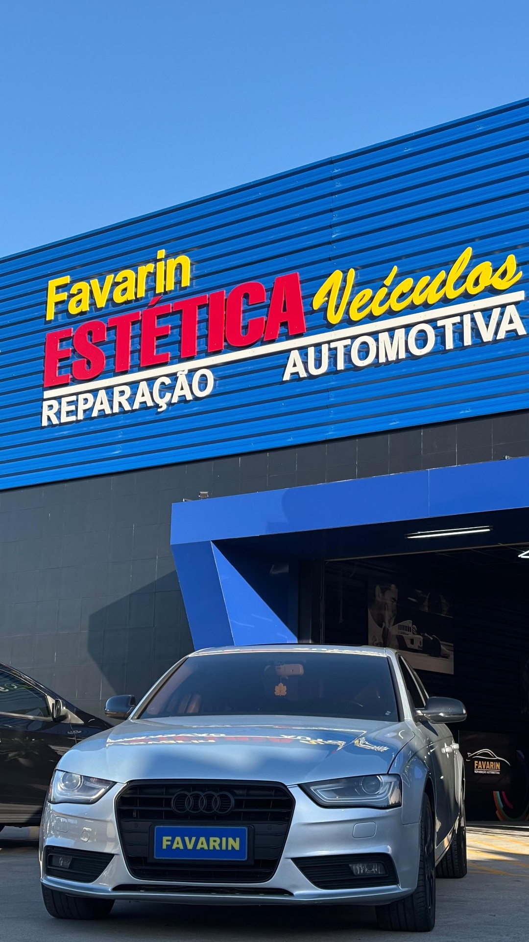 Audi estacionado em frente à fachada da Favarin destacando a marca da oficina.